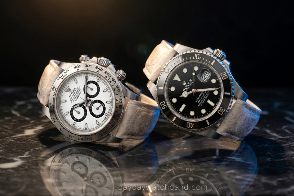 Rolex Daytona and Rolex Submariner both fitted with alligator leather watch strap, side by side on marble surface, showing Rolex on a leather strap from two iconic models by Daydaywatchband