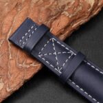 Detail of Patek Philippe Calatrava Pilot Travel Time 5524 replacement strap showing Calatrava cross-stitch pattern and navy calfskin keeper loop