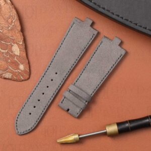 Grey nubuck strap for Vacheron Constantin Overseas displayed on warm tan leather background